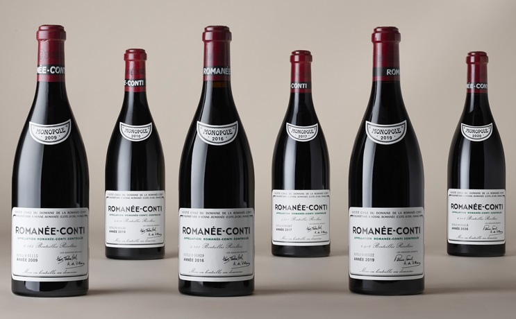 Six bottles of Romanée-Conti wine from different years are displayed in a row.