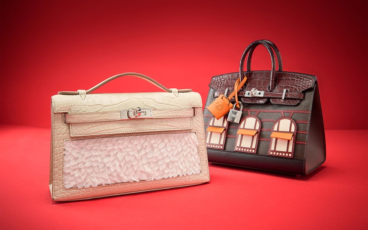 Two luxury handbags, one cream-colored with textured details and one dark brown with orange accents.