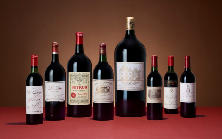 A selection of eight assorted wine bottles is displayed against a red and brown background.