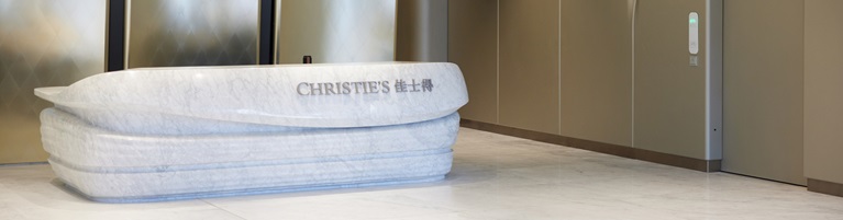 A modern marble reception desk with "CHRISTIE