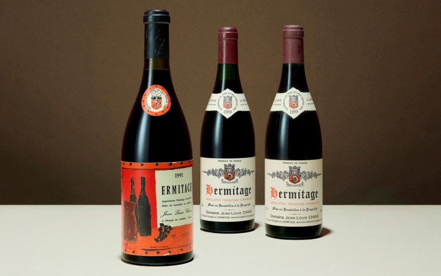 Three bottles of Domaine Jean-Louis Chave Hermitage red wine are displayed on a light surface.